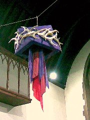 Gold crown of thorns on purple, with red and purple streamers