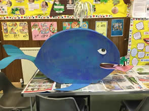 Cardboard model of a blue coloured whale blowing a spout from its blowhole