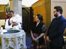 Revd. Ola Franklin baptising a child at the font in St Pauls' church